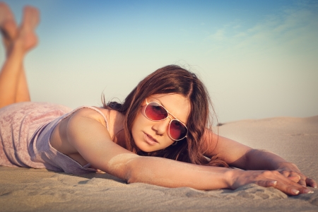 Girl lying on the sandの写真素材