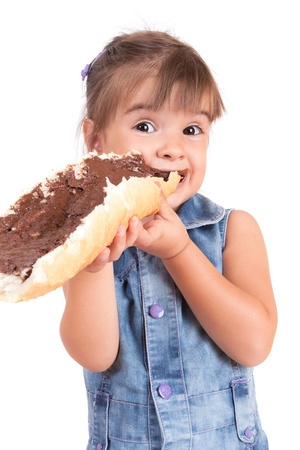 beautiful little girl eats bread with chocolate creamの写真素材