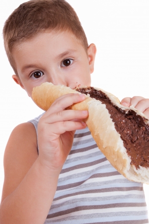 beautiful little boy eats bread with chocolate creamの写真素材