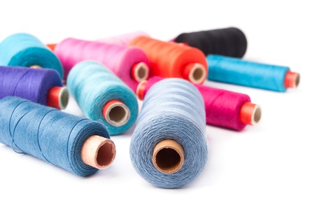 Colorful thread bobbins, isolated on white background 