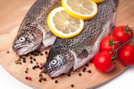 trout on a wooden board with spices の写真素材