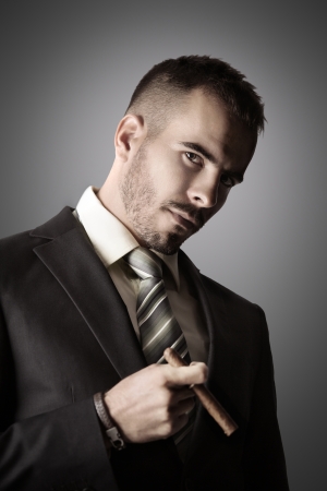 Attractive businessman is smoking a cigarの写真素材