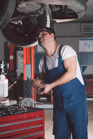 Car mechanic working in auto repair serviceの写真素材