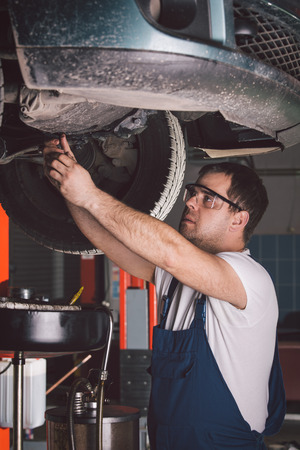Car mechanic working in auto repair serviceの写真素材