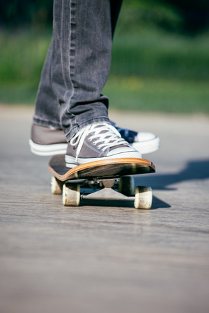 Legs in sneakers on a skateboard の写真素材