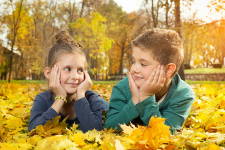 Child lying on the golden leafの写真素材