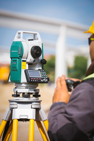 Surveyor engineer worker making measuring with theodolite tool equipment at construction siteの写真素材