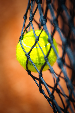 Tennis ball in netの写真素材