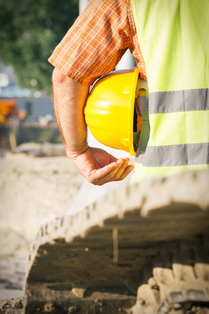 Construction worker holding yellow hardhatの写真素材