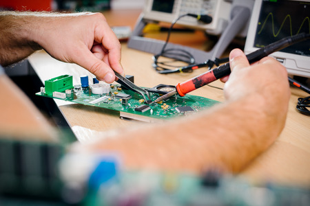 Tech tests electronic equipment in service center