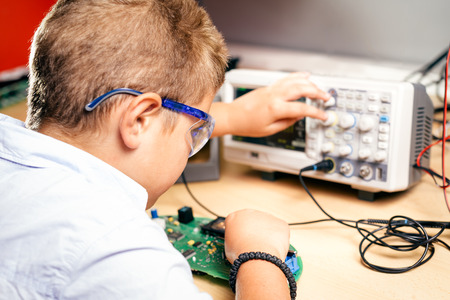 Young boy working on an electronics projectの写真素材