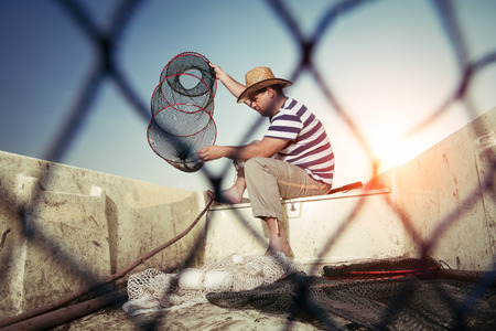 Fisherman checking the net for a catchの写真素材