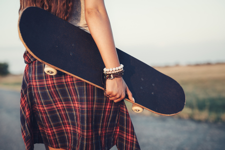 Close up of a teenage girl holding skateboardの写真素材