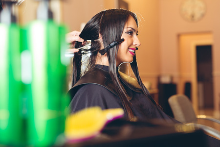 Professional hairdresser dyeing hair of her clientの写真素材