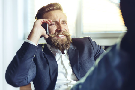Hipster businessman relaxing at his desk in his officeの写真素材