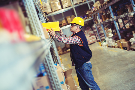 Worker In Warehouse Preparing Goods For Dispatchの写真素材
