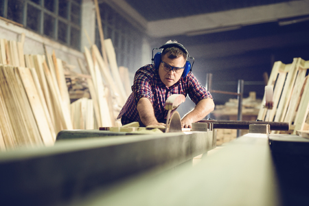 Carpenters cutting wooden plank with a circular sawの写真素材
