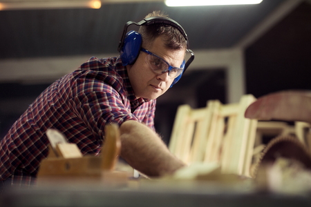Carpenters cutting wooden plank with a circular sawの写真素材