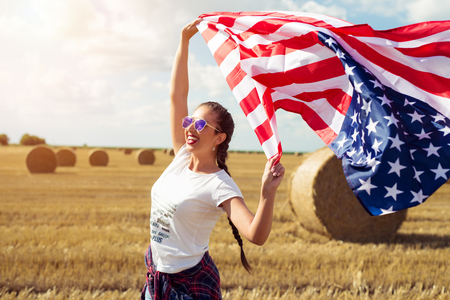 Young beautiful woman holding USA flagの写真素材