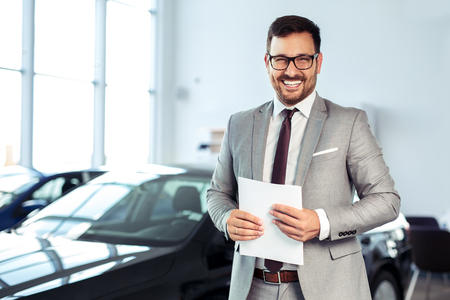 Salesperson at car dealership selling vehiclesの写真素材