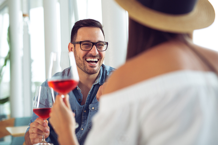 Happy couple dining and drink wine at restaurantの写真素材