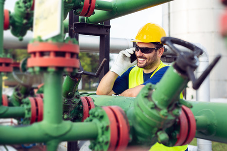 Oil and gas and pipelines with engineer talking in phoneの写真素材