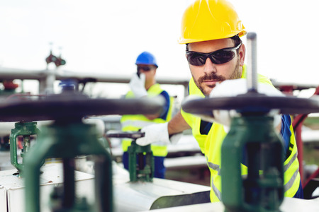 Oil worker closes the valve on the oil pipeline