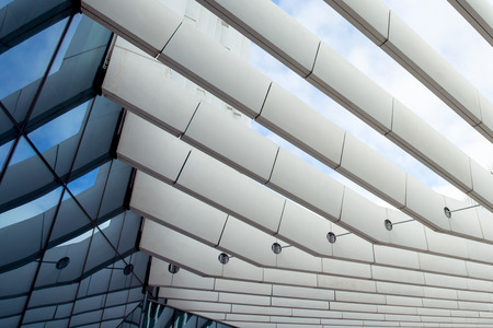 Photo of a modern steel grid with a reflection of a clear blue sky.