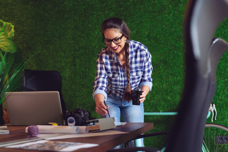 Female engineer working in her office with a cup of coffee in hands.