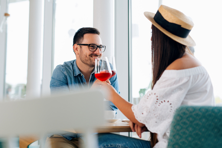 Happy couple romantic date drink glass of red wine at restaurant.の写真素材