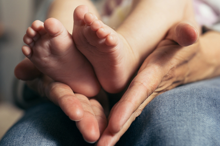 Baby feet in mother hands. Happy Family concept.の写真素材