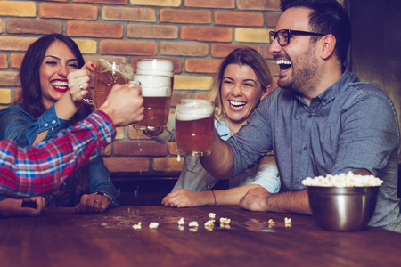 Two couples went on a double date to pub on a saturday night. - Imageの写真素材