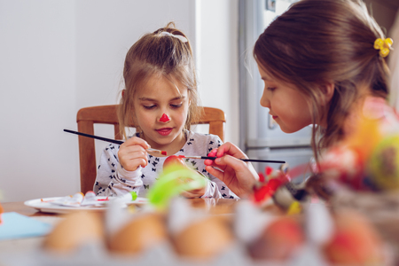 Happy easter! A beautiful child girl painting Easter eggs.の写真素材
