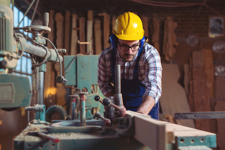 Carpenter working with circular saw at carpentry workshop