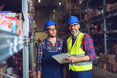 Two warehouse workers filling in documentの写真素材