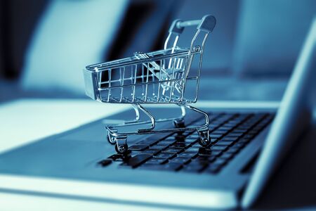 Shopping cart with laptop on the desk, online shopping concept.