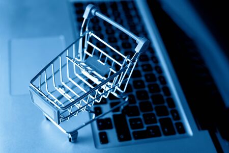 Shopping cart with laptop on the desk, online shopping concept.