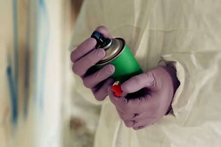 Spraying graffiti close up. Graffiti artist painting.