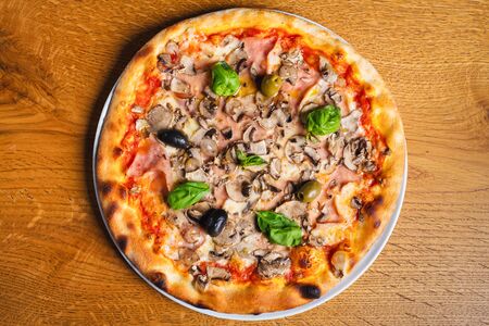 Delicious italian pizza served on wooden tableの写真素材