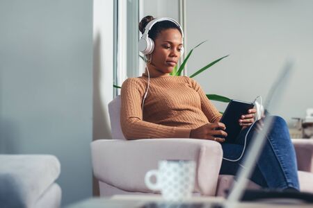 African woman relaxing and listening to music.