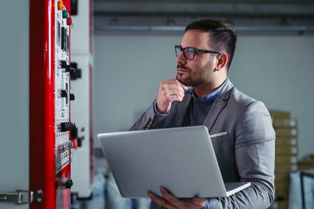 Engineer in the factory using laptop computer for maintenance.の写真素材