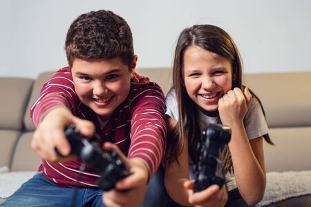 Happy children playing computer games at home