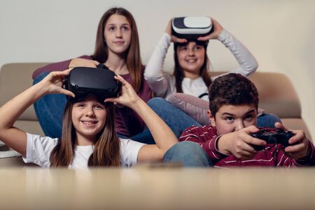 Teenagers playing video game at home.