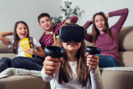 Teenagers playing video game at home.