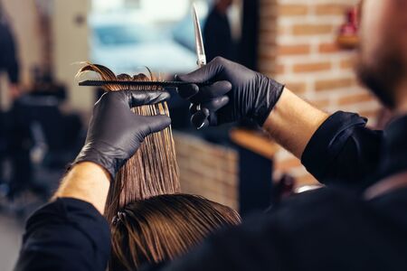 Male client getting haircut by hairdresser. Modern hair salon concept.の写真素材