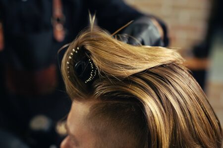 Barber drying male hair in hairdressing salon.の写真素材