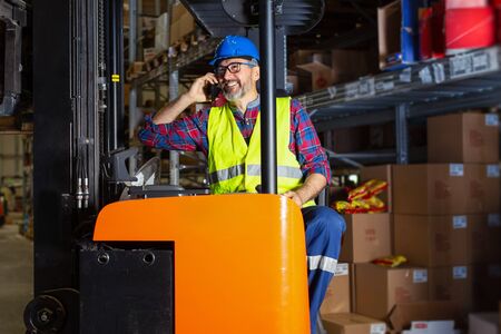 Warehouse worker talking on the phone .