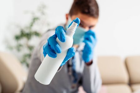 Boy in a medical mask holds a disinfectant in his hands an antiseptic for hands. COVID-19 disinfects hands.の写真素材