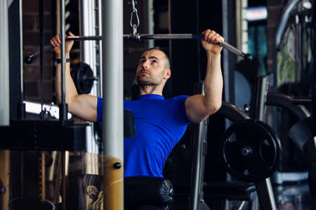 Fit man exercising at the gym on a machine.