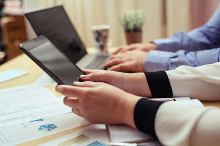 Woman with bills and smart phone at the tableの写真素材